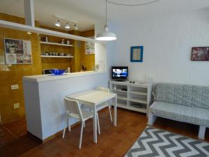 uma sala de estar com uma mesa e um sofá e uma cozinha em Rigel Es Pujols em Es Pujols