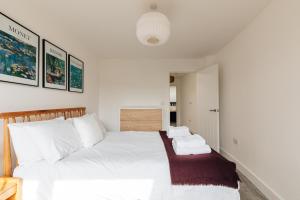 een slaapkamer met een bed met witte lakens en kussens bij Redland Stay In Bespoke Home 2 of 2 in Bristol