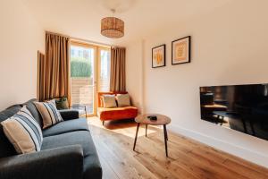 een woonkamer met een bank en een tv bij Redland Stay In Bespoke Home 2 of 2 in Bristol