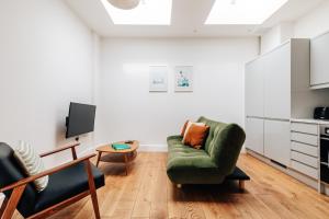 uma sala de estar com uma cadeira verde e uma mesa em Redland Stay In Bespoke Home 1 of 2 em Bristol
