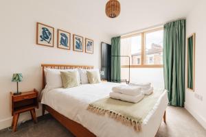 um quarto com uma cama grande e cortinas verdes em Redland Stay In Bespoke Home 1 of 2 em Bristol