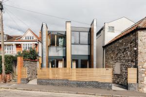 a house with a stone wall and a wooden fence at Redland Stay In Bespoke Home 1 of 2 in Bristol