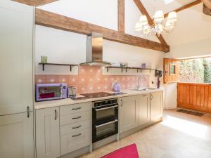 een keuken met witte kasten en een fornuis met oven bij The Forge in Taunton