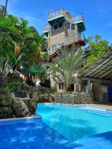 uma casa com piscina em frente a um edifício em Hotel Tunco Lodge em La Libertad