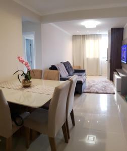 een woonkamer met een tafel en een bank bij Apartamento de Luxo com Piscina em Bombinhas in Bombinhas