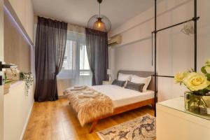 a small bedroom with a bed with a tufted bedspread at Historical Center by 4EL in Bucharest