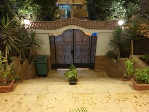 una gran puerta en un jardín con macetas en YOUVALA Serviced Apartment 2nd District, en Seis de Octubre