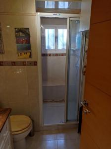 a bathroom with a toilet and a glass shower at Apartamento Árbol de vida - cerca Estadio Cartuja in Seville