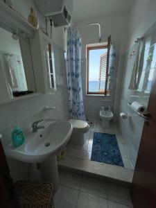 bagno con lavandino, servizi igienici e finestra di Casa Caterina ad Acquacalda