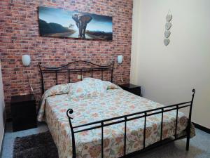 プエルト・デル・ロサリオにあるApartment Severo Ochoaのレンガの壁、ベッド付きのベッドルーム1室