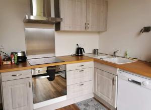 a kitchen with white cabinets and wooden counter tops at Gite mes pt'tis lits maison chaleureuse 4 chambres in Neufmarché