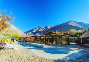un complejo con piscina y montañas de fondo en Refugios Pisco Elqui, en Pisco Elqui