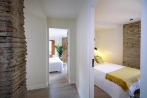 a bedroom with a bed and a brick wall at Albaicin Alhambra Views private terrace in Granada