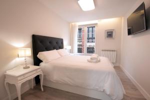 Un dormitorio con una gran cama blanca y una ventana en Casa Ochoa en Logroño