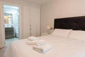 a bedroom with white towels on a white bed at Casa Ochoa in Logroño