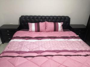 a bed with a pink blanket and pink pillows at Al-Shokhaibie 51 Building- Soufan Studios in Ţāb Kirā‘