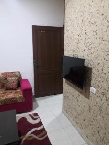 a living room with a tv on a wall at Al-Shokhaibie 51 Building- Soufan Studios in Ţāb Kirā‘