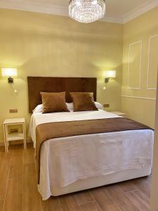 - une chambre avec un grand lit et un lustre dans l'établissement SUITES SAN ESTEBAN 16 Ducal, à Séville