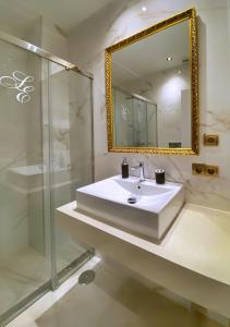 La salle de bains est pourvue d'un lavabo, d'une douche et d'un miroir. dans l'établissement SUITES SAN ESTEBAN 16 Ducal, à Séville