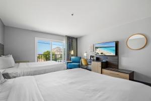 a hotel room with two beds and a television at Hotel Avisa Downtown in Morro Bay