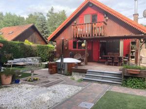 una casa roja con un patio frente a ella en Le Petit Chalet avec hottub., en Sint-Gillis-Waas