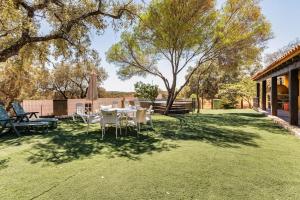 a yard with a table and chairs on the grass at Casa Rural Navalonguilla con piscina in Santa Olalla del Cala
