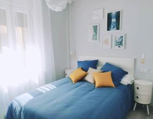 Un dormitorio con una cama azul con almohadas amarillas en Casa "El Villar", en Matabuena