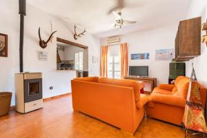 sala de estar con muebles de color naranja y chimenea en Casa Rural Navalonguilla con piscina en Santa Olalla del Cala