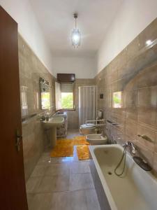 bagno con 2 lavandini, vasca e 2 servizi igienici di La casa di Mussiù a Salemi