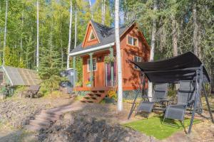 ein kleines orangenes Haus mit schwarzer Decke davor in der Unterkunft The Skarland Trail Cabin in Fairbanks