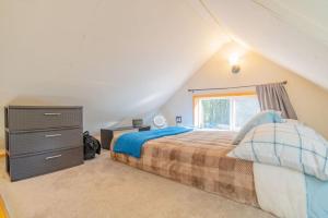 ein Schlafzimmer mit einem Bett mit einer Kommode und einem Fenster in der Unterkunft The Skarland Trail Cabin in Fairbanks