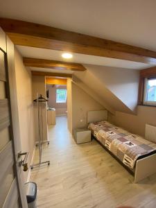 een kamer met een bed in het midden van een zolder bij BALTIC VIBES - pokoje gościnne in Kołobrzeg