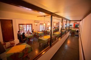 una stanza con persone sedute ai tavoli in un ristorante di Hosteria Los Helechos a Puerto Iguazú