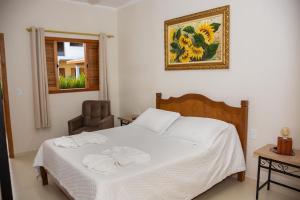 um quarto com uma cama com duas toalhas em Pousada Pôr do Sol em Cunha