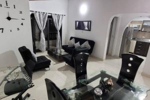 - un salon avec des chaises noires et une table en verre dans l'établissement central apartamento al lado del polideportivo sur de envigado, à Envigado