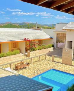 una casa con piscina frente a una casa en Pousada Pôr do Sol en Cunha