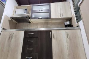 a kitchen with wooden cabinets and a microwave at central apartamento al lado del polideportivo sur de envigado in Envigado