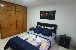 - une chambre avec un lit et des oreillers bleus dans l'établissement central apartamento al lado del polideportivo sur de envigado, à Envigado