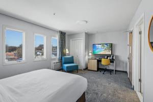 um quarto com uma cama, uma secretária e uma televisão em Hotel Avisa Downtown em Morro Bay