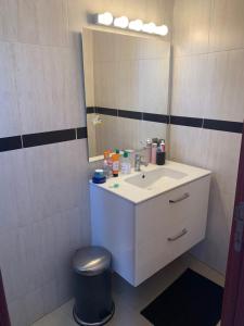 y baño con lavabo y espejo. en Au Bord du palmier, en Rabat