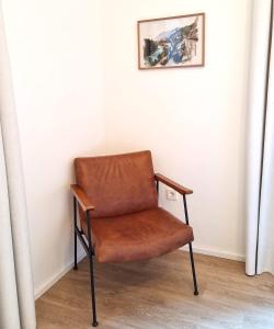 a brown chair sitting in the corner of a room at Apartment Emilie with parking historic city center in Merano