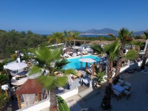 an aerial view of a resort with a pool and palm trees at Bella Vista Hôtel, Suites & Maisons in Porticcio
