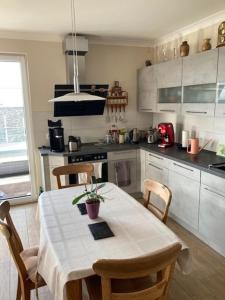 a kitchen with a white table and chairs and a kitchen with at Ferienwohnung Troge in Greifswald