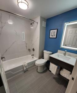 a bathroom with a tub and a toilet and a sink at La Quinta by Wyndham Houston Stafford Sugarland in Stafford