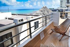 une chaise assise sur un balcon donnant sur l'océan dans l'établissement Ocean view apartment, best beach area, 3 bedrooms, à Cancún