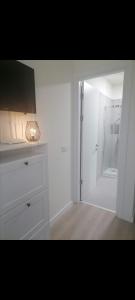 baño blanco con ducha y puerta de cristal en Tom's House en Otopeni