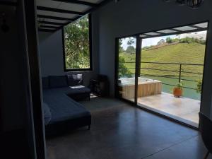 ein Wohnzimmer mit einer Badewanne und einem großen Fenster in der Unterkunft Finca 2 - Dakeva in Guatapé