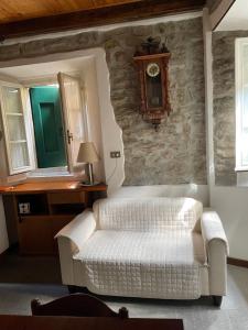 a living room with a white couch and a clock on the wall at Appartamento Santi in Fiumalbo