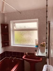 baño con lavabo, ventana y bañera en 'Melrose' at stayBOOM en Lancaster