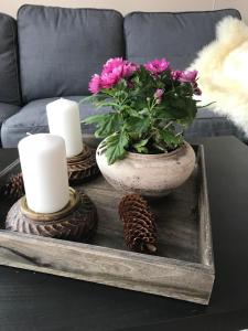 Una mesa con un jarrón con flores y velas. en Beitotind sentralt på Beitostølen, en Beitostølen
